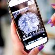 Close-up of hands holding a smartphone displaying a brain MRI scan on the screen