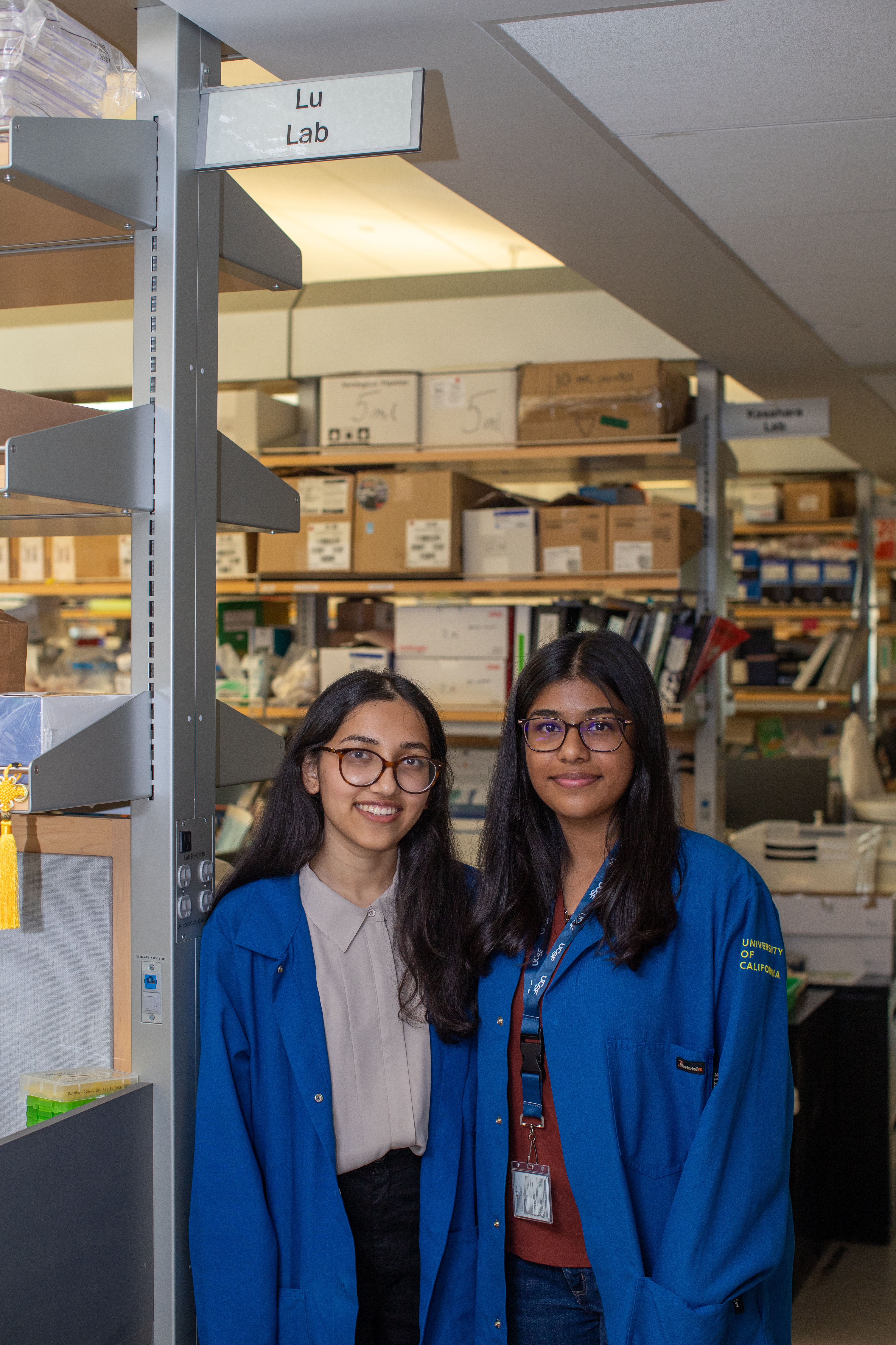 Two people standing below a sign that reads "Lu Lab"