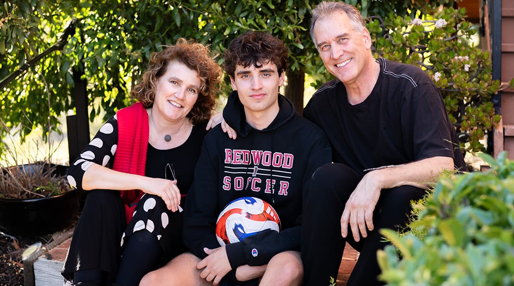 Marcos Ornellas seated between his parents, Elena Vives and Chris Ornellas